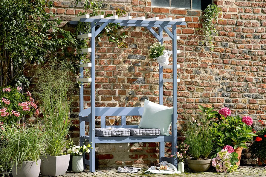 Blaue Gartenbank mit Pergola